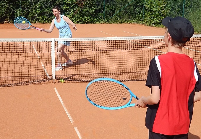 Eine Frau und ein Kind spielen Tennis
