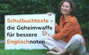 Eine Frau in oranger Bluse sitzt im Gras. Neben ihr ein Flipchart. Darauf steht: Schulbuchtexte, die Geheimwaffe für bessere Noten in Englisch.