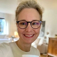 Monika-Frauendorfer-229 Das Porträt einer blonden Frau mit Brille.